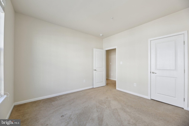 empty room with carpet and baseboards