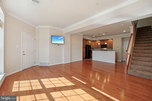 unfurnished living room with stairway, wood finished floors, visible vents, and baseboards