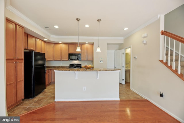 kitchen with crown molding, visible vents, black appliances, dark stone counters, and a kitchen breakfast bar