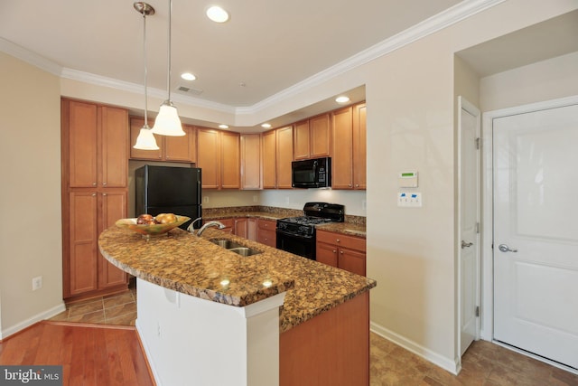 kitchen with black appliances, visible vents, a sink, and ornamental molding