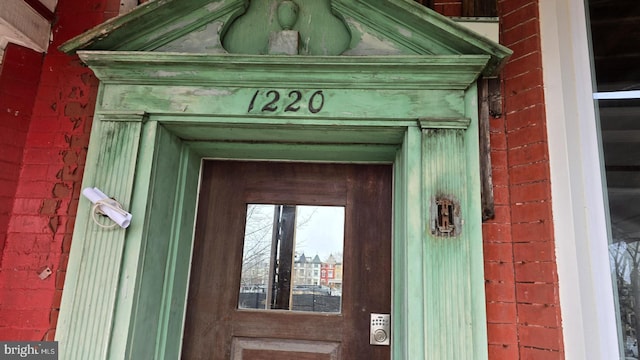 entrance to property featuring brick siding