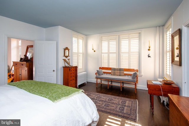 bedroom featuring radiator heating unit, wood finished floors, and baseboards