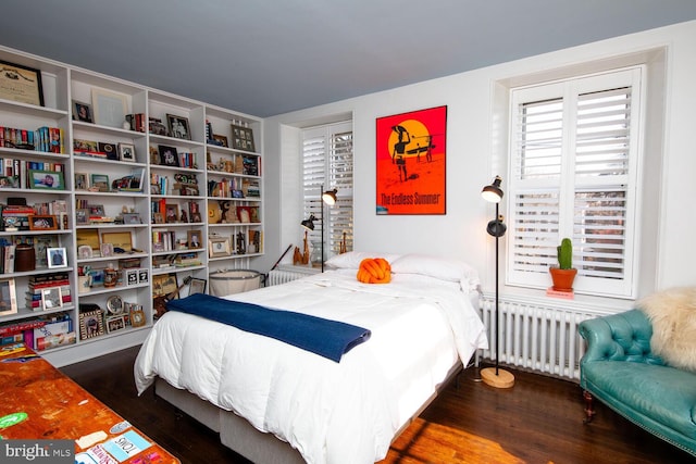 bedroom featuring radiator heating unit and wood finished floors