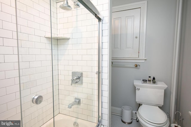 bathroom featuring washtub / shower combination, tile patterned flooring, baseboards, and toilet