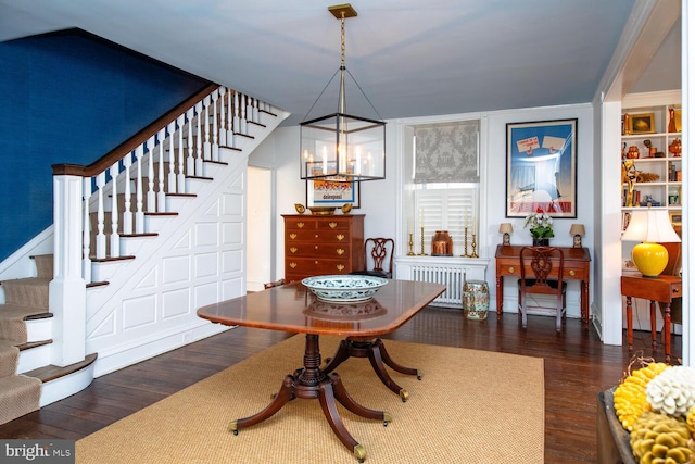 dining room featuring stairway, dark wood-style flooring, and radiator