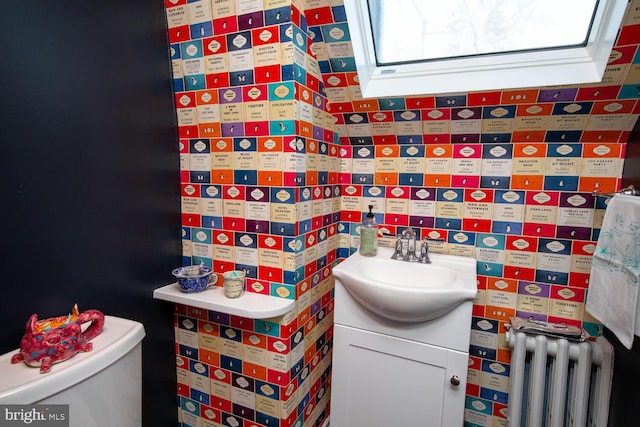 bathroom featuring toilet, vanity, and radiator