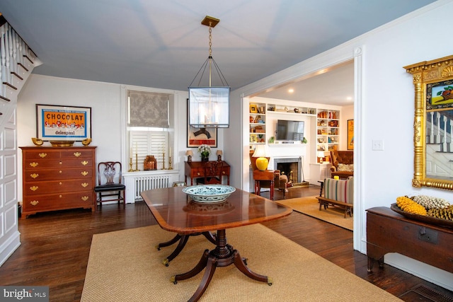 sitting room featuring radiator, crown molding, a fireplace, and wood finished floors