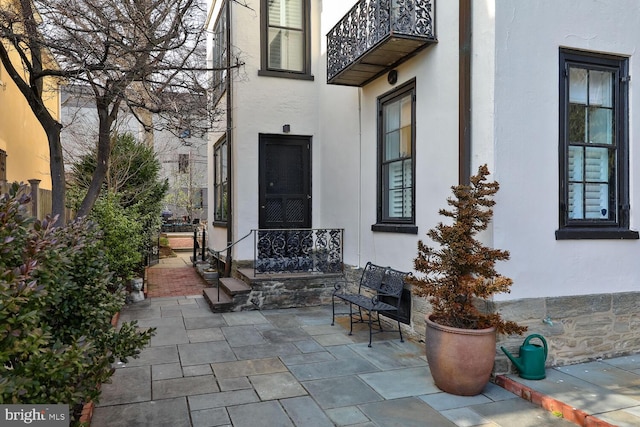 property entrance featuring a patio area and stucco siding