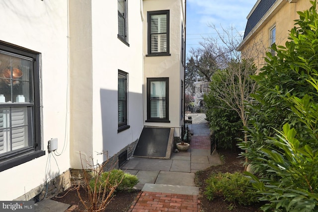 view of side of property featuring a patio and stucco siding