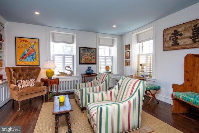 sitting room featuring baseboards, a healthy amount of sunlight, radiator heating unit, and hardwood / wood-style flooring