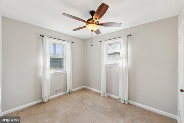 spare room featuring baseboards, light colored carpet, and a healthy amount of sunlight