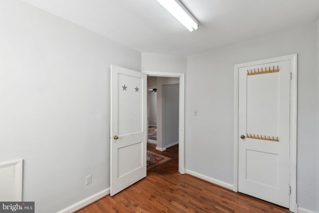 unfurnished bedroom featuring wood finished floors and baseboards