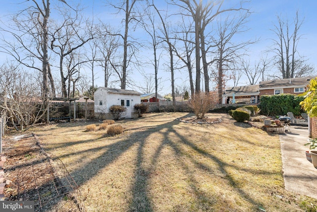 view of yard with fence and an outdoor structure