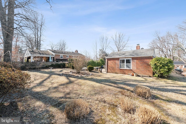 exterior space with a chimney and brick siding