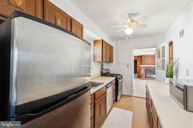 kitchen featuring stainless steel appliances, light countertops, brown cabinetry, and visible vents