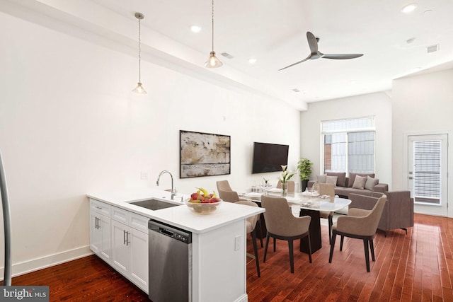 kitchen with a peninsula, a sink, dark wood-style floors, open floor plan, and dishwasher