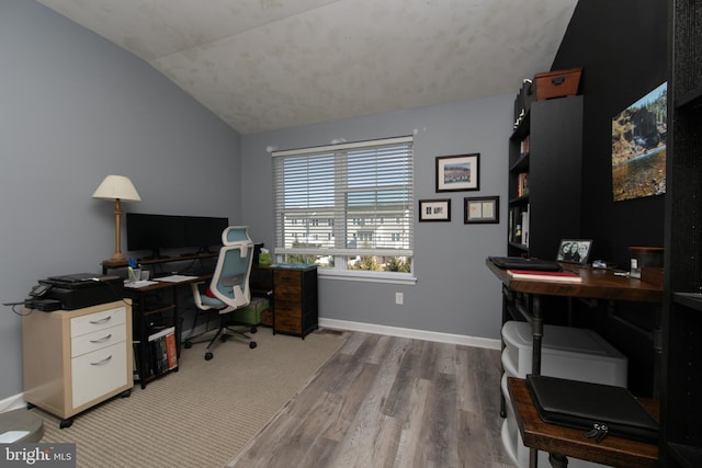 office space with vaulted ceiling, wood finished floors, and baseboards