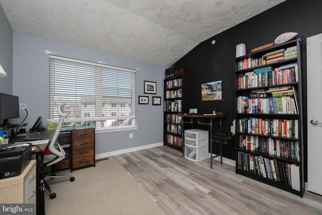 office area featuring vaulted ceiling, baseboards, and wood finished floors