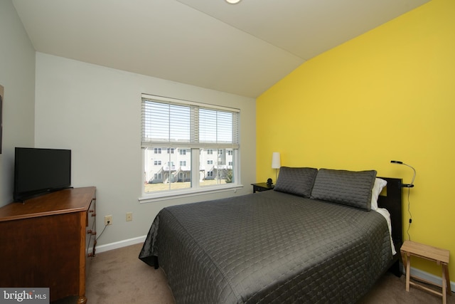 carpeted bedroom featuring vaulted ceiling and baseboards