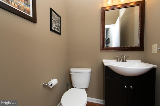 bathroom featuring vanity, toilet, and baseboards