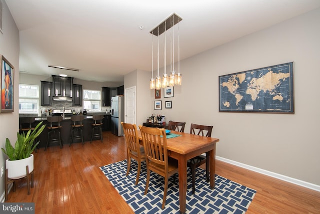 dining space featuring baseboards and light wood-style floors