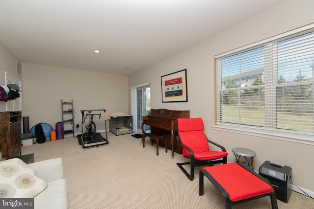 sitting room featuring a wealth of natural light, visible vents, and carpet flooring