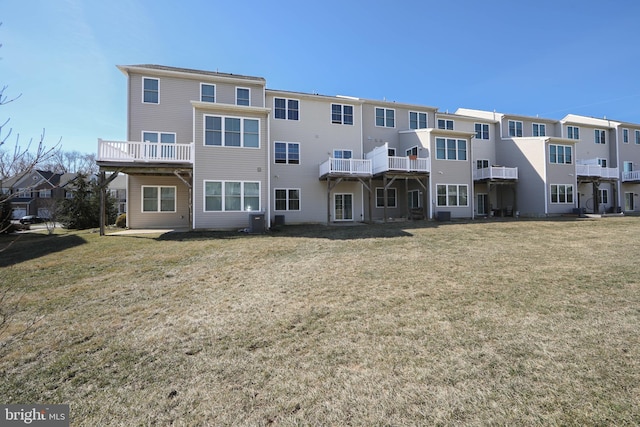 rear view of house featuring a lawn and cooling unit