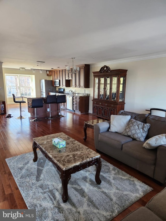 living room featuring dark wood-style flooring, rail lighting, and crown molding