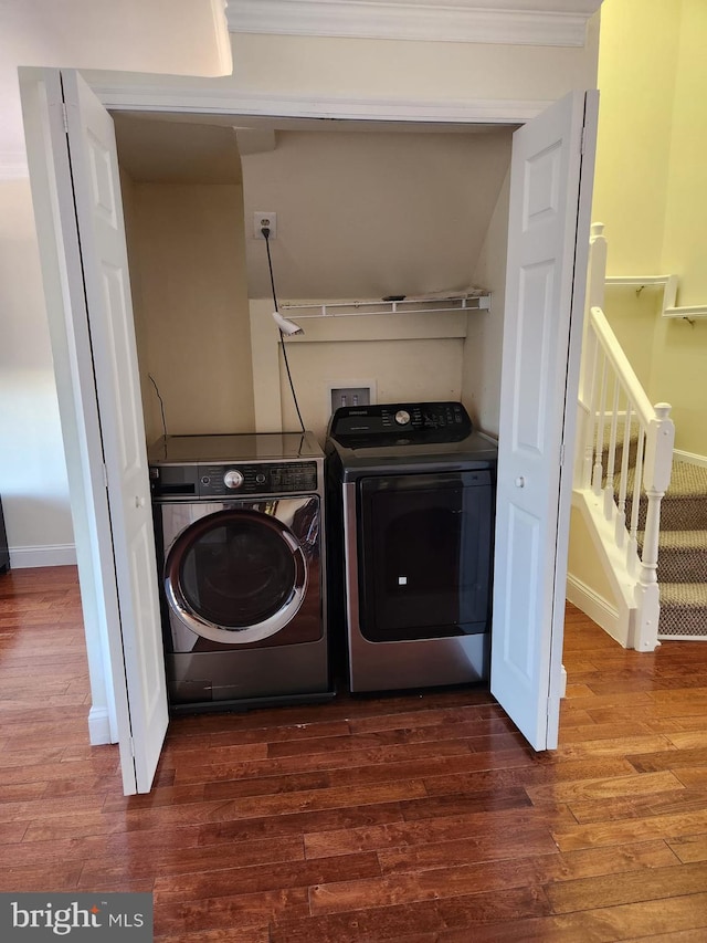 laundry room with laundry area, baseboards, separate washer and dryer, and dark wood finished floors