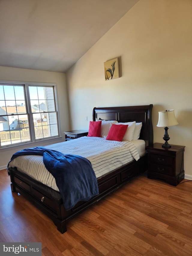 bedroom featuring vaulted ceiling, wood finished floors, and baseboards