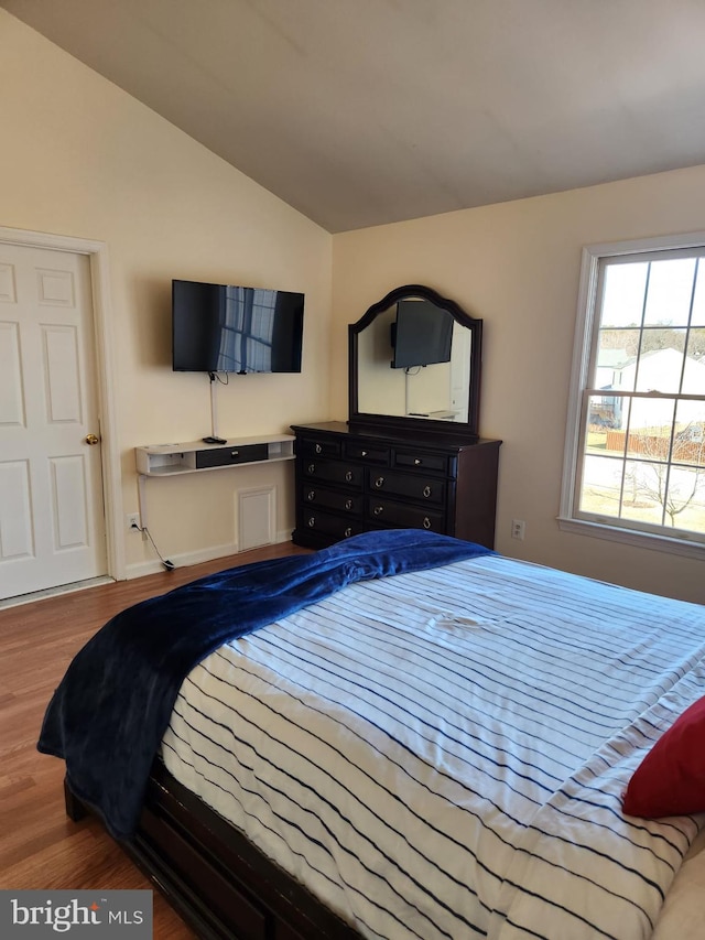 bedroom featuring vaulted ceiling and wood finished floors