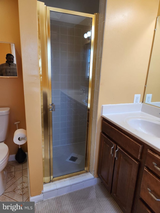 full bathroom with vanity, a shower stall, toilet, and tile patterned floors