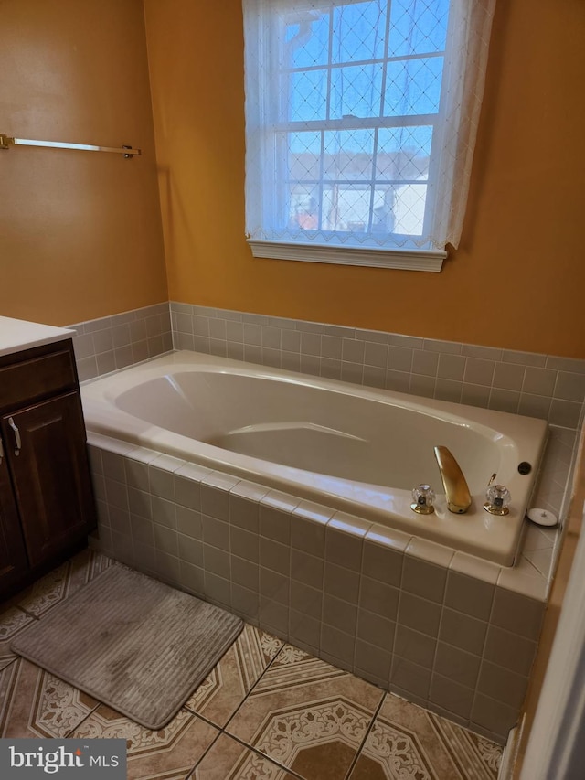 full bath with a garden tub, tile patterned flooring, and vanity