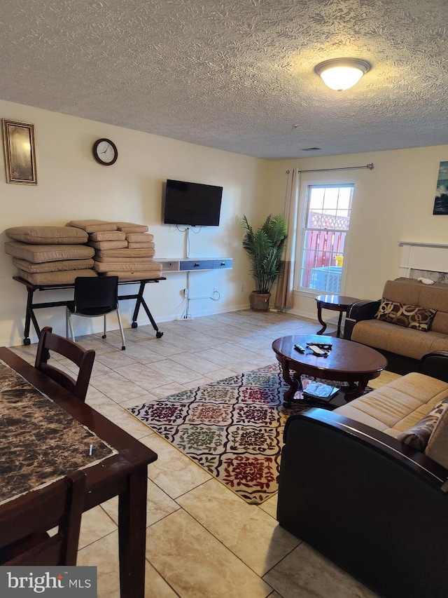 living area featuring a textured ceiling and tile patterned floors