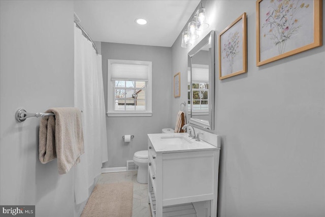 full bathroom featuring visible vents, baseboards, a shower with shower curtain, toilet, and vanity