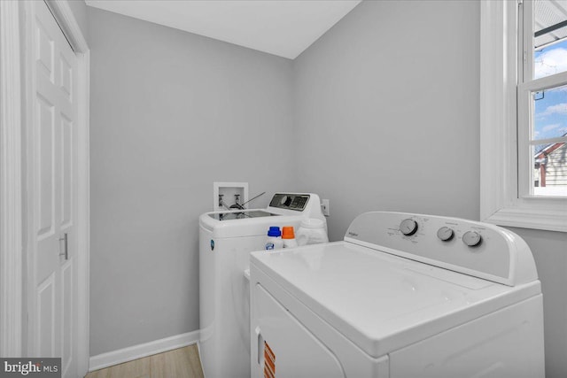 clothes washing area with laundry area, independent washer and dryer, light wood finished floors, and baseboards