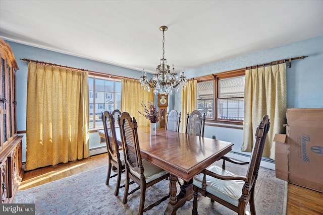 dining area featuring an inviting chandelier, wood finished floors, and a baseboard radiator