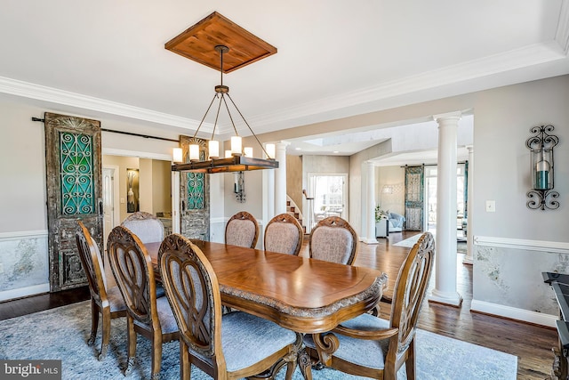 dining area with dark wood-type flooring, crown molding, and ornate columns