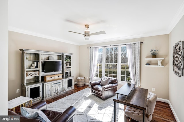 living area with crown molding, dark wood finished floors, a ceiling fan, and baseboards