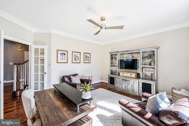 living room featuring baseboards, ceiling fan, ornamental molding, and wood finished floors