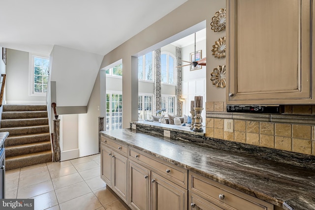 kitchen featuring open floor plan, a peninsula, light tile patterned floors, and a healthy amount of sunlight