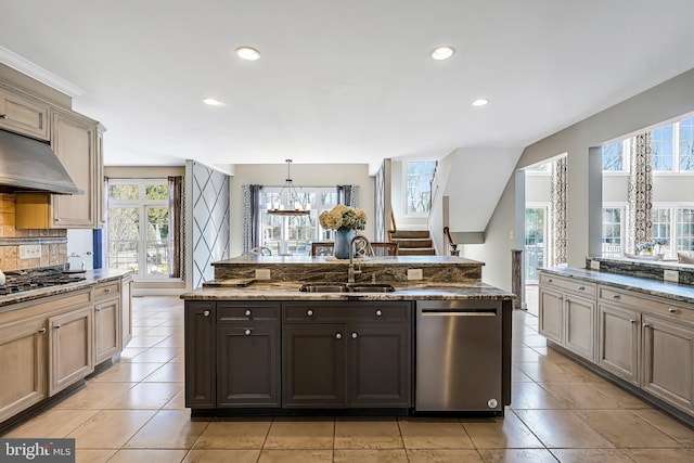 kitchen featuring stone countertops, stainless steel dishwasher, under cabinet range hood, gas cooktop, and a sink