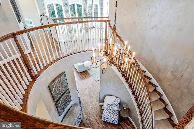 stairway with a chandelier and wood finished floors