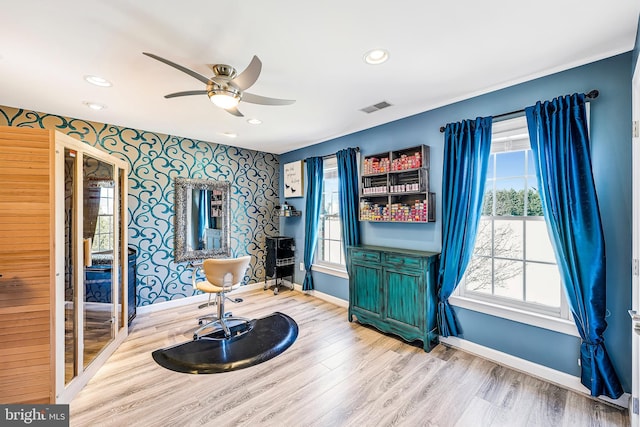 living area featuring wallpapered walls, plenty of natural light, visible vents, and baseboards