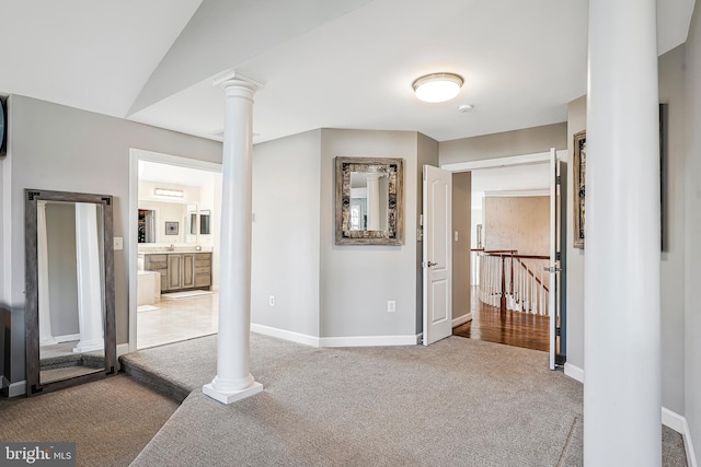 bedroom featuring lofted ceiling, baseboards, carpet flooring, and ornate columns