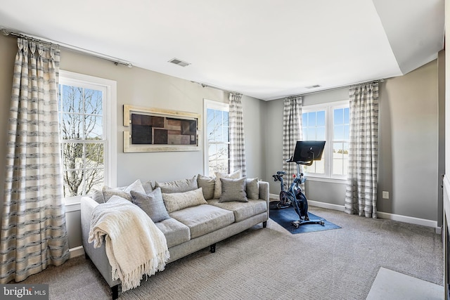 living area with carpet floors, visible vents, and baseboards