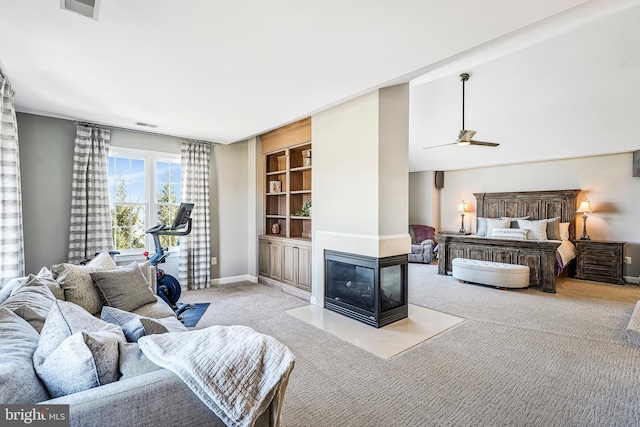 bedroom with carpet, baseboards, visible vents, and a multi sided fireplace