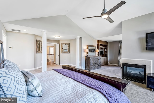 bedroom with visible vents, lofted ceiling, carpet, ornate columns, and a multi sided fireplace