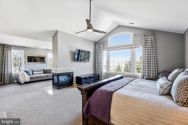 bedroom featuring lofted ceiling, multiple windows, carpet flooring, and a multi sided fireplace