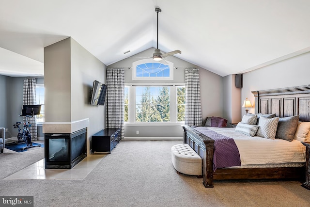 bedroom featuring carpet floors, multiple windows, a multi sided fireplace, and lofted ceiling